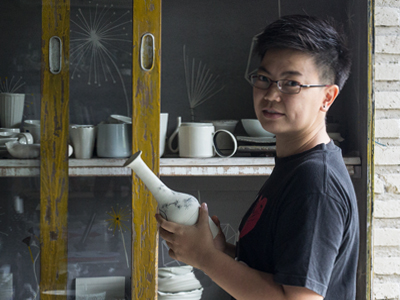 A maker inspecting a handmade ceramic piece in the studio